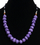 Collier ethnique artisanal imitation boules mauves difformes, separees de perles en metal avec d'autres en bois, noires, bleues et blanches