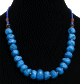 Collier ethnique artisanal imitation pierres difformes blues separees de petites perles en metal, avec d'autres perles bleues, marrons et noires
