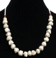 Collier ethnique artisanal imitation pierres blanches difformes separees de perles en metal et compose de perles blanches