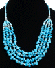 Collier ethnique artisanal quatre rangs imitation pierres turquoises agremente d'armatures argentees ciselees et de perles